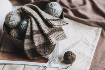 Hand knitted socks with needles and yarn ball in a basket. Concept for handmade and hygge slow life.