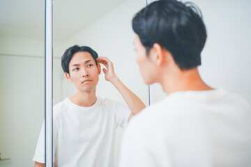 洗面所でヘアセットをする男性