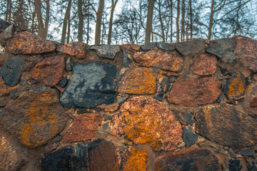A stone wall with a path made of cement pavement. Masonry building in winter.