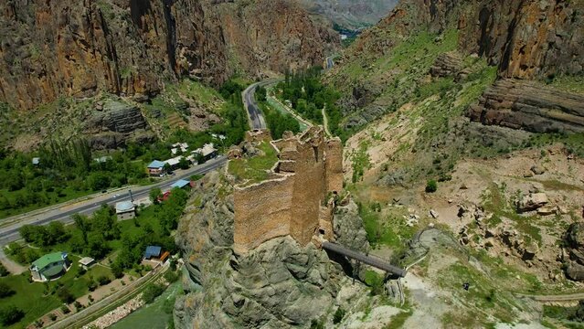 Erzurum Enguzek Castle is in ruins by the river and has been waiting for centuries Mountains clouds in the sky