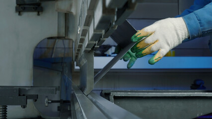 Close up of worker pressing metal at workshop. Creative. Sheet metal hydraulic CNC press brake...