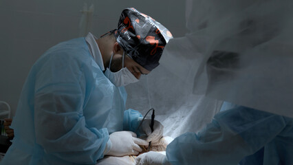 Team of doctors and surgeons processing surgical operation in operating room. Action. Modern...