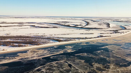 Aerial drone view of frozen lakes in a bog in winter. Clip. Endless snow covered fields and swamps.