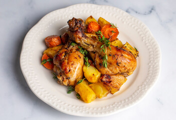 Baked chicken thighs and fried potatoes look delicious.