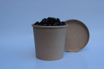 Coffee beans in a brown paper cup and white background