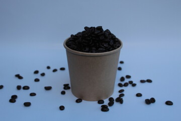 Coffee beans in a brown paper cup and white background