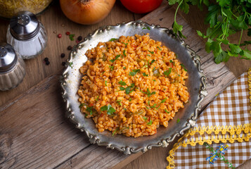 Traditional turkish bulgur pilaf with tomato sause in plate (Turkish name; meyhane pilavi)