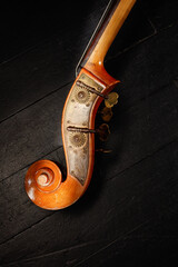 Ancient brown double bass neck, double bass scroll and tuning pegs. Vintage Contrabass head with...