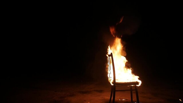 The chair is on fire. Big mystical fire at night.	