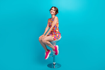 Full length photo of positive shiny girl dressed print outfit sitting bar chair smiling isolated...