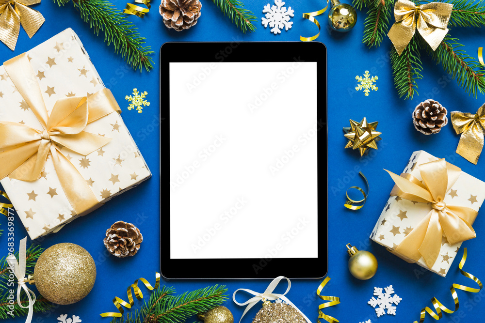 Wall mural Digital tablet mock up with rustic Christmas decorations for app presentation top view with empty space for you design. Christmas online shopping concept. Tablet with copy space on colored background