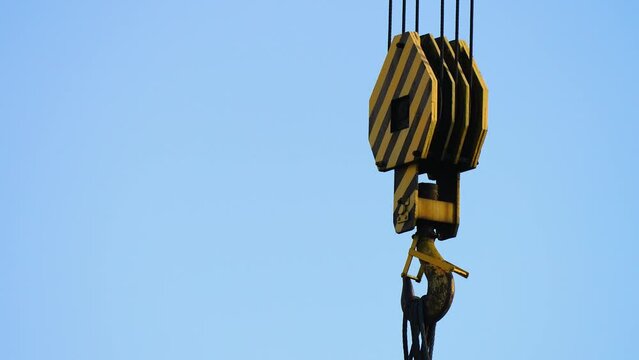 Close up Lockdown Shot Of Crane Hook Block Hanging On Wire Rope Slings. Parts of construction crane, hook and slings