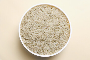 Raw basmati rice in a white bowl on a light background. Concept of Water-Conserving Products. Saving water. Vegetarian and vegan food. Healthy Eating. Horizontal orientation. Top view.