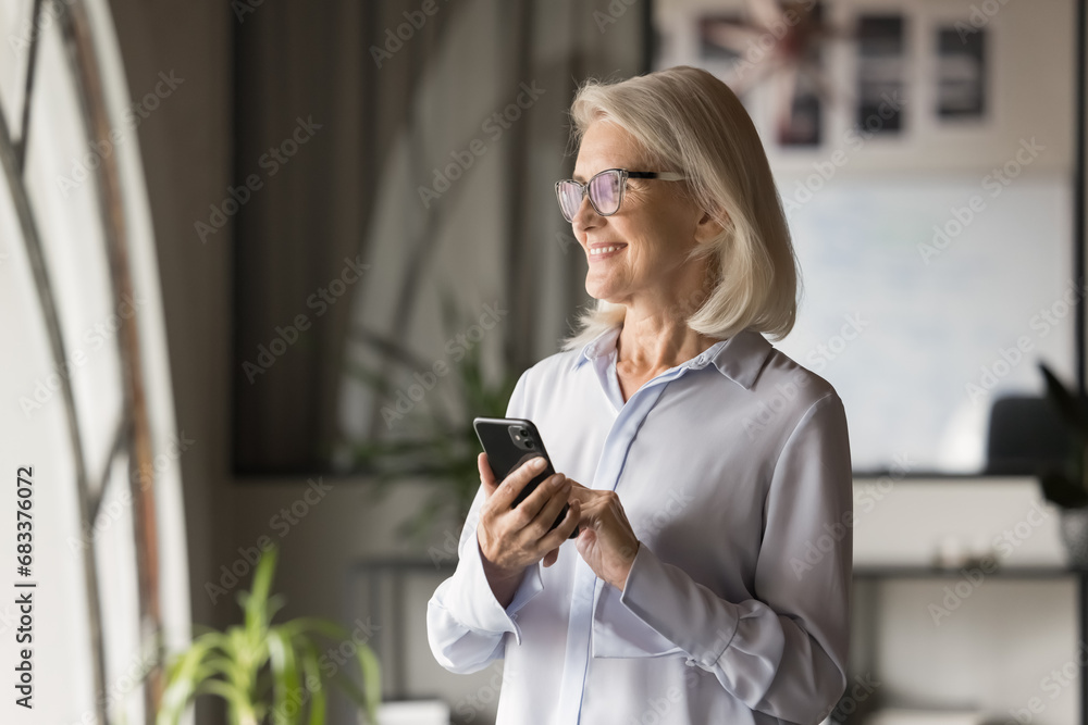 Canvas Prints cheerful elderly business professional woman in glasses getting good news on online chat, holding sm