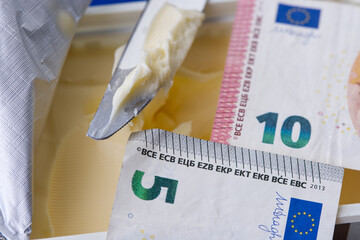 Salted butter in pack, knife and euro banknotes.