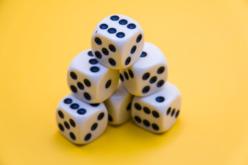 white dice stacked up on a yellow background. win or lose. catch your luck. gambling equipment.