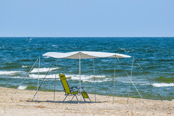 Beach chair and umbrella on the beach - shelter from the sun