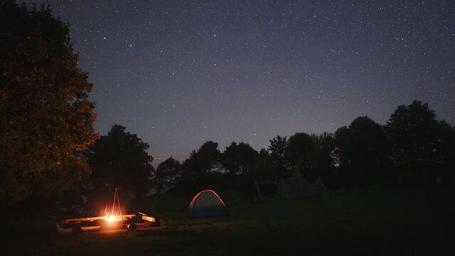 Time lapse of a night at a campsite with tents and campfire