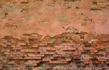 Very old damaged red brick wall with boneless bricks and cement mortar