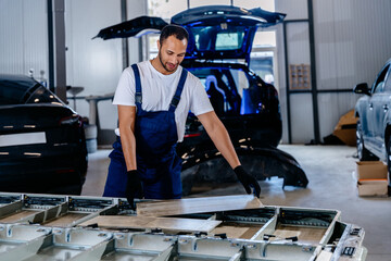 Installation of an electric vehicle battery before repair. Underbody of an electric car of electric...