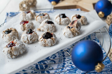 Christmas cookies. Italian almonds cookies with red and dark currant jam on decorated white background.