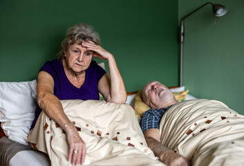 Senior woman can't sleep because her husband is snoring
