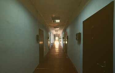 The gloomy corridor of a neglected public building. Public space in a poor residential high-rise building