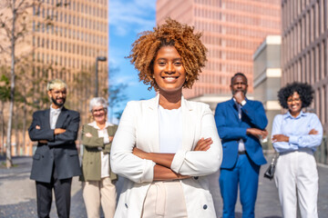 Smiling african businesswoman standing serious next to colleagues