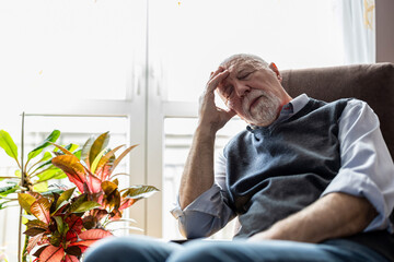 Senior man sleeping in an armchair at home
