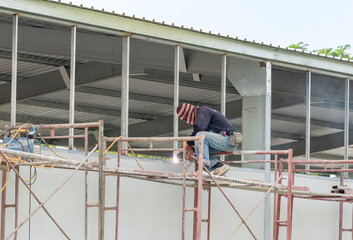 Side view of welder is welding the window.