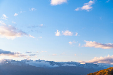 冠雪した北アルプスと紅葉した山