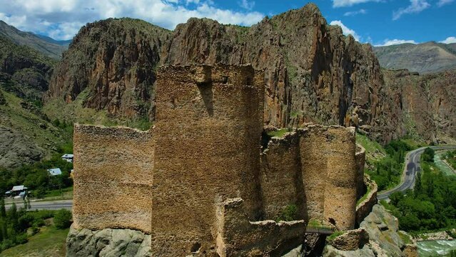 Erzurum Enguzek Castle is in ruins by the river and has been waiting for centuries Mountains clouds in the sky