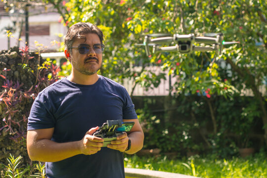 A middle aged man operating a small aerial drone at the park. A typical hobbyist operator.