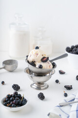 Ice cream with blueberries and blackberries. Homemade vanilla ice cream with berries in metal bowls