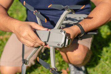 A man attaches a fresh and fully-charged battery onto a consumer level drone prior to a flight.