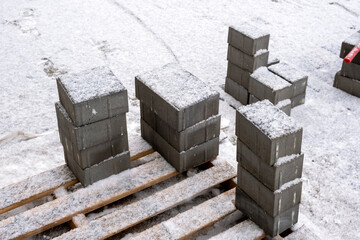 Small paving slabs covered with snow at a construction site