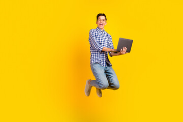 Photo of excited guy wear shirt spectacles jumping typing modern device isolated vibrant color...