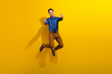 Fototapeta na wymiar Full body photo of satisfied funky man wear bow tie stylish shirt jumping showing thumbs up to you isolated on yellow color background