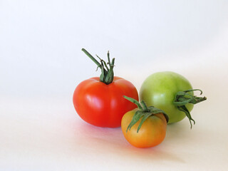 Three tomatoes - ripe, unripe and something in between