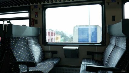 Empty train seats with nobody, landscape passing by in background. High-speed transportation