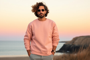 Man wearing a high-quality Flat Blank Plane crewneck Light Pink color Sweatshirt Mockup with oversized look and sunglasses and nature mountain background - Powered by Adobe