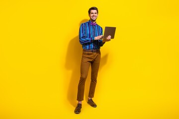 Full body photo of intelligent man wear stylish shirt vintage bow tie holding laptop typing message isolated on yellow color background - obrazy, fototapety, plakaty