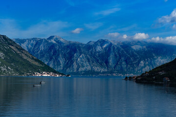 Fototapeta na wymiar nature landscape of Boka Kotorska Bay in Montenegro, stunning green mountains, adriatic sea, stone houses, sailing boats, calm water with reflections