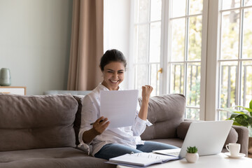Smiling Indian woman read paper notification about last loan payment rejoice great news written in notice feels happy. Student pass exam, celebrate university admission, scholarship approval concept - obrazy, fototapety, plakaty