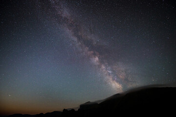 starry sky with the milky way and mountains on the horizon