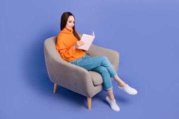 Full body length photo of cheerful mature lady sitting in armchair reading her memories copybook isolated on purple color background
