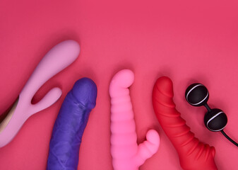 Vibrator sex toys for women on a pink background stock photo images. Set of erotic vaginal toys images. Dildo, vibrators and love balls on a pink background with copy space - obrazy, fototapety, plakaty