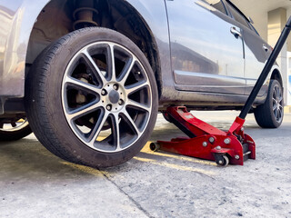 Car Lifted With Hydraulic Floor Jack For Repairing Change Wheel, Tire Leak