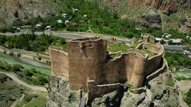 Erzurum Enguzek Castle is in ruins by the river and has been waiting for centuries Mountains clouds in the sky