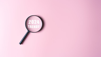 Magnifier with word 2024 TREND inside on pink background. Trend marketing monitor for business...